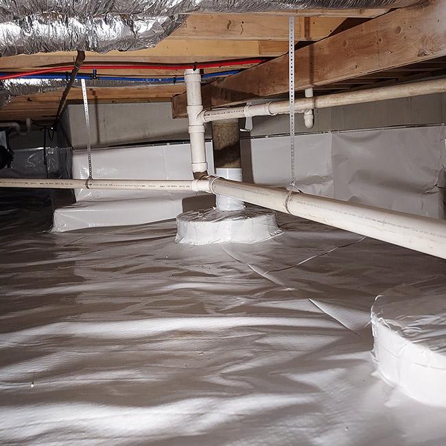 Crawl Space after encapsulation with vapor barrier and sealed pipes