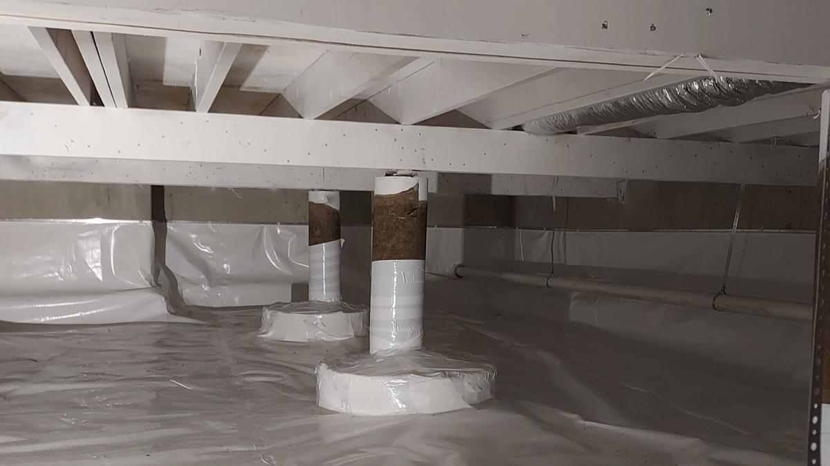 Encapsulated crawl space with white vapor barrier on walls and floor