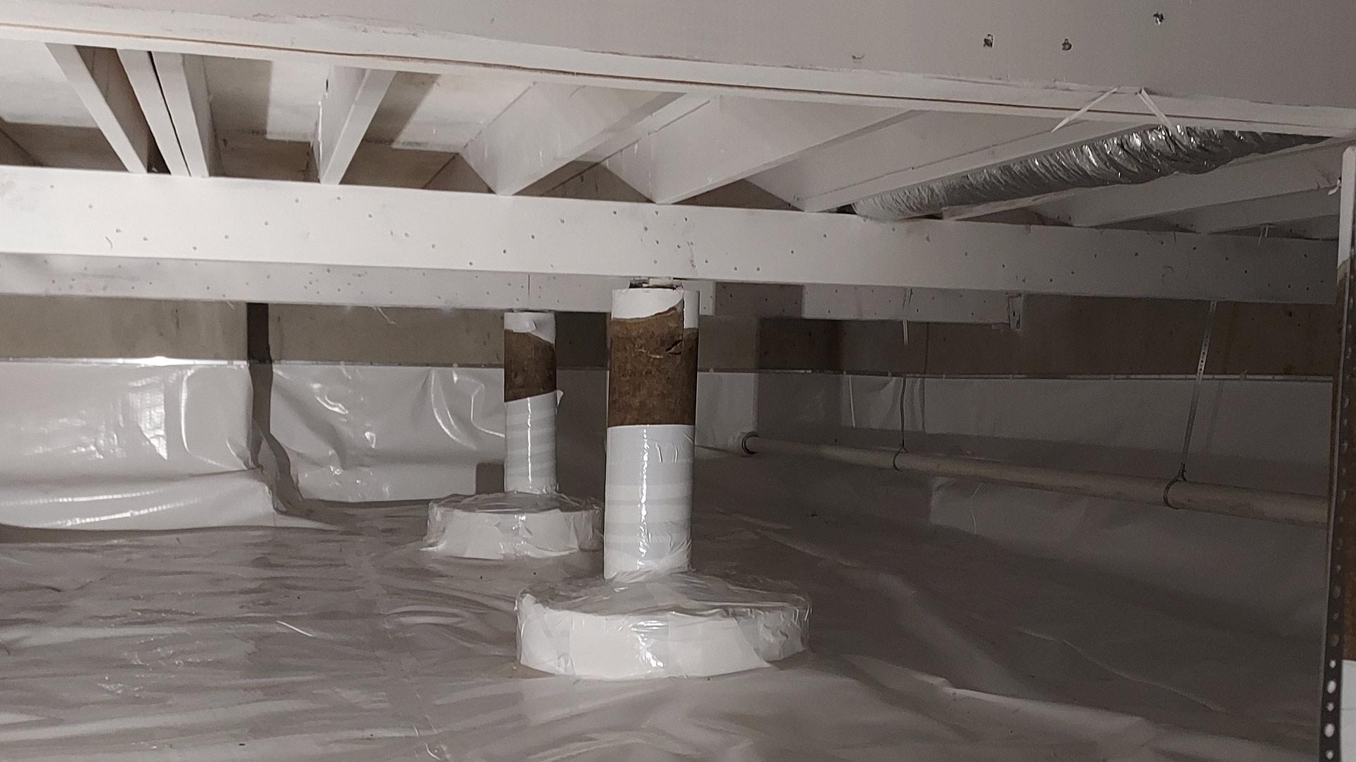Encapsulated crawl space with white vapor barrier on walls and floor