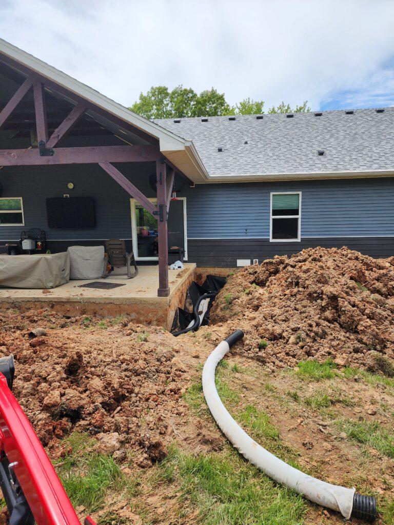 Drainage pipe installation with excavation at a home