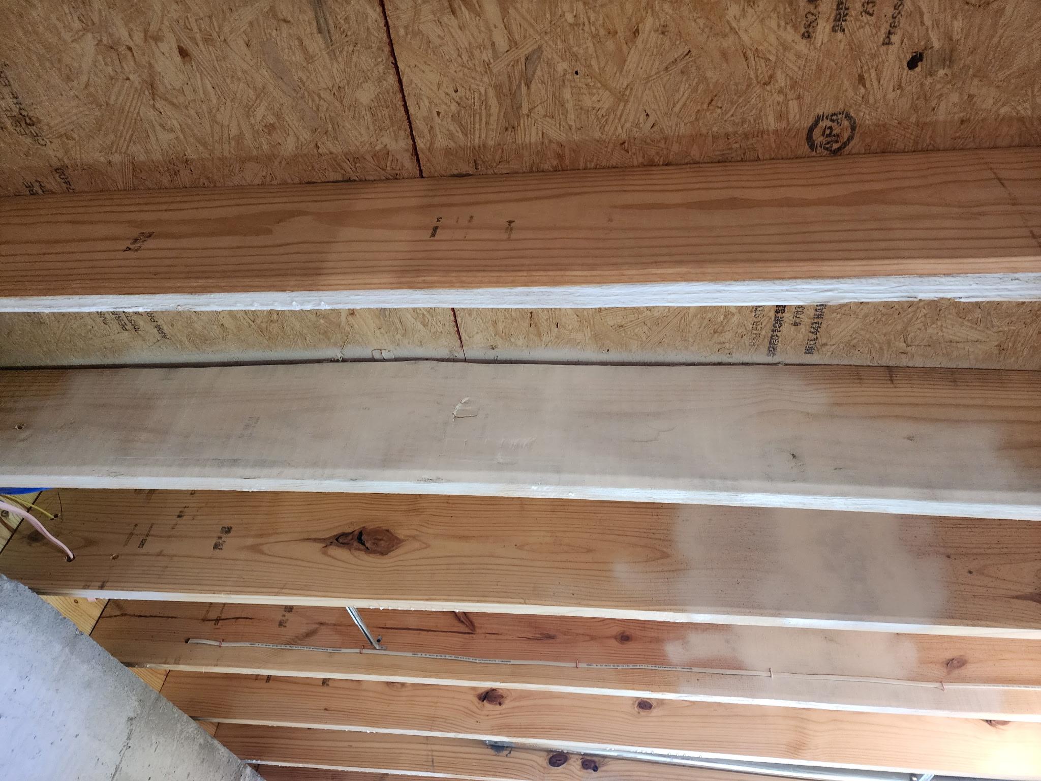 Original photograph: floor joists in a new-construction crawl space that another contractor painted over instead of properly remediating the mold underneath