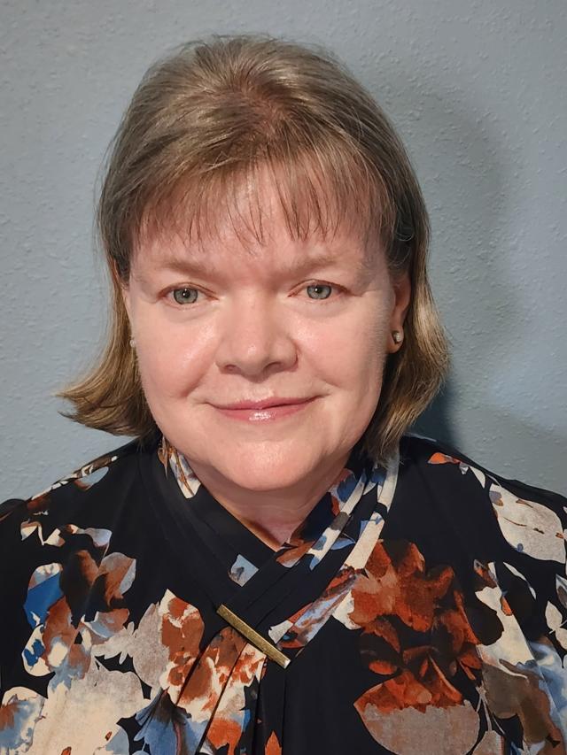 Original photograph: Jana Tetley, Co-Owner and CFO of TLC Land Crew, smiling in a floral-pattern blouse